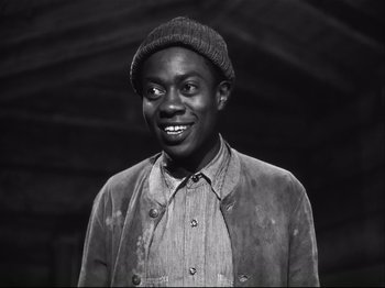 Movie still from “High Sierra” (1940), directed by Raoul Walsh – A black and white photo of a man smiling; Medium shot, High angle