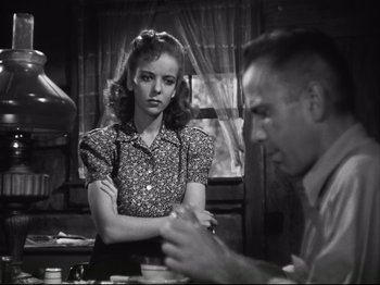 Movie still from “High Sierra” (1940), directed by Raoul Walsh – A woman standing next to a man in front of a window; Medium shot, Over the shoulder angle