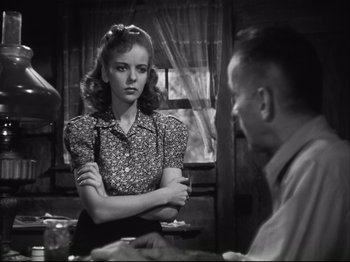 Movie still from “High Sierra” (1940), directed by Raoul Walsh – A woman standing next to a man in front of a window; Medium shot, Over the shoulder angle