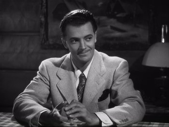 Movie still from “High Sierra” (1940), directed by Raoul Walsh – A man sitting at a table with a pen in his hand; Close Up shot, Low angle