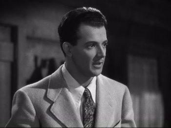 Movie still from “High Sierra” (1940), directed by Raoul Walsh – A black and white photo of a man wearing a suit and tie; Close Up shot, Low angle