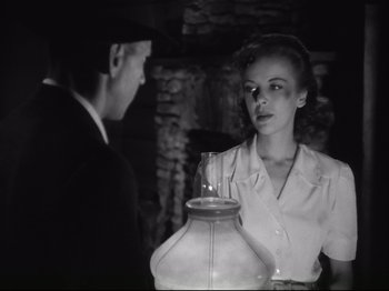 Movie still from “High Sierra” (1940), directed by Raoul Walsh – A woman standing next to a man holding a vase; Medium shot, High angle