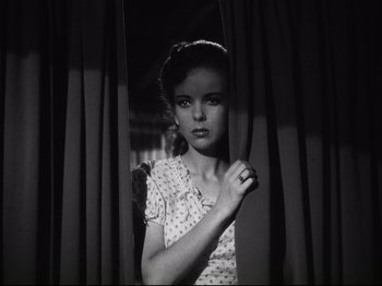 Movie still from “High Sierra” (1940), directed by Raoul Walsh – A young woman standing in front of a curtain; Medium shot, Low angle