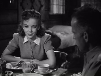 Movie still from “High Sierra” (1940), directed by Raoul Walsh – A woman sitting at a table with a cup of coffee; Medium shot, Over the shoulder angle