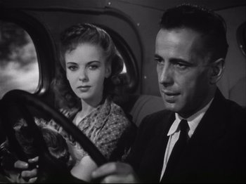 Movie still from “High Sierra” (1940), directed by Raoul Walsh – A man and a woman sitting in the back of a car; Close Up shot, Low angle