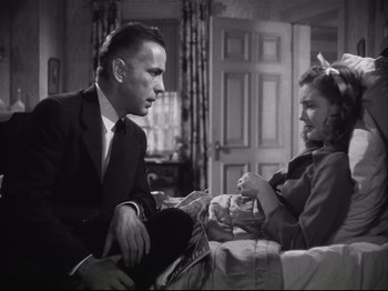 Movie still from “High Sierra” (1940), directed by Raoul Walsh – A man and a woman sitting on a couch talking to each other; Medium shot, Low angle