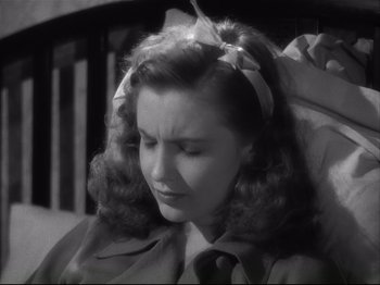 Movie still from “High Sierra” (1940), directed by Raoul Walsh – A woman with a bow in her hair looking down; Close Up shot, High angle