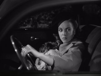 Movie still from “High Sierra” (1940), directed by Raoul Walsh – A woman driving a car with a dog in her lap; Close Up shot, High angle