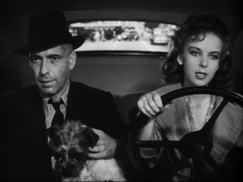 Movie still from “High Sierra” (1940), directed by Raoul Walsh – A man and a woman sitting in the back of a car; Medium shot, Low angle