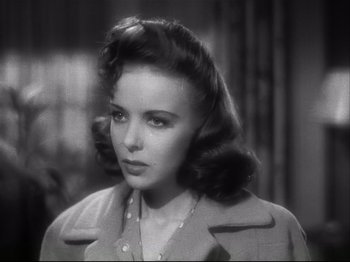 Movie still from “High Sierra” (1940), directed by Raoul Walsh – A black and white photo of a woman in a trench coat; Close Up shot, Over the shoulder angle