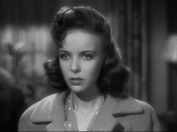 Movie still from “High Sierra” (1940), directed by Raoul Walsh – A black and white photo of a woman in a trench coat; Close Up shot, High angle