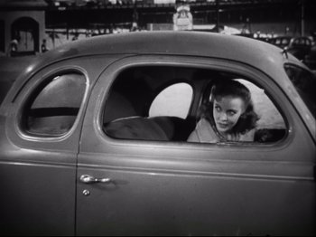 Movie still from “High Sierra” (1940), directed by Raoul Walsh – A woman sitting in the driver's seat of an old car; Medium shot, High angle