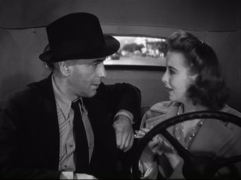 Movie still from “High Sierra” (1940), directed by Raoul Walsh – A man and a woman sitting in a car talking to each other; Close Up shot, Over the shoulder angle