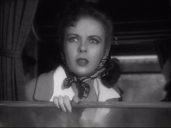 Movie still from “High Sierra” (1940), directed by Raoul Walsh – A black - and - white photo of a woman looking out a window; Close Up shot, Low angle