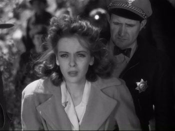 Movie still from “High Sierra” (1940), directed by Raoul Walsh – An old photo of a woman being escorted by a police officer; Close Up shot, Low angle