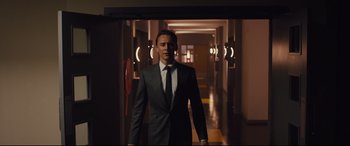 Movie still from “High-Rise” (2015), directed by Ben Wheatley – A man wearing a suit and tie in a hallway; Medium shot, Low angle