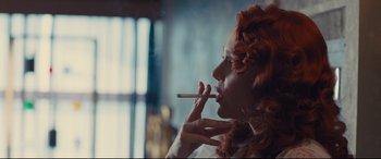 Movie still from “High-Rise” (2015), directed by Ben Wheatley – A woman smoking a cigarette while looking into the distance; Close Up shot, Low angle