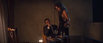 Movie still from “High-Rise” (2015), directed by Ben Wheatley – A man and a woman sitting at a dinner table; Medium shot, Over the shoulder angle