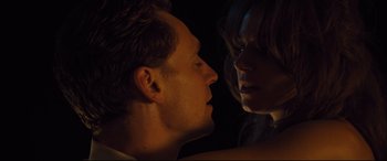 Movie still from “High-Rise” (2015), directed by Ben Wheatley – A man and a woman face to face in the dark; Close Up shot, Low angle