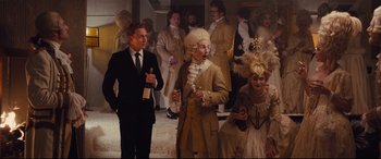 Movie still from “High-Rise” (2015), directed by Ben Wheatley – A group of people dressed up in costumes; Medium shot, Over the shoulder angle