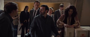 Movie still from “High-Rise” (2015), directed by Ben Wheatley – A group of people walking in a room; Medium shot, Over the shoulder angle