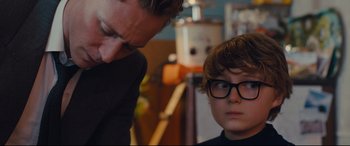 Movie still from “High-Rise” (2015), directed by Ben Wheatley – A man and a boy wearing glasses looking at each other; Close Up shot, Over the shoulder angle