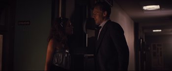 Movie still from “High-Rise” (2015), directed by Ben Wheatley – A man and a woman in a dark room talking to each other; Medium shot, Over the shoulder angle