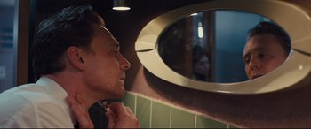 Movie still from “High-Rise” (2015), directed by Ben Wheatley – A man looking in a mirror while brushing his teeth; Close Up shot, Over the shoulder angle