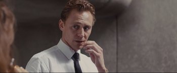 Movie still from “High-Rise” (2015), directed by Ben Wheatley – A person wearing a suit and tie; Close Up shot, Low angle