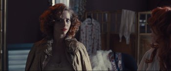 Movie still from “High-Rise” (2015), directed by Ben Wheatley – A woman with red curly hair standing next to a bed; Close Up shot, Over the shoulder angle