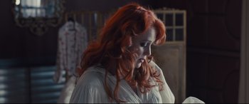 Movie still from “High-Rise” (2015), directed by Ben Wheatley – A woman with long red hair is looking down; Medium shot, Low angle