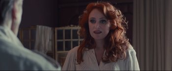 Movie still from “High-Rise” (2015), directed by Ben Wheatley – A woman with long red hair is looking at the camera; Close Up shot, Over the shoulder angle