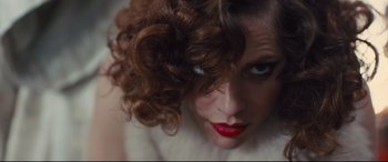 Movie still from “High-Rise” (2015), directed by Ben Wheatley – A person with curly brown hair; Extreme Close Up shot, Overhead angle