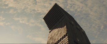 Movie still from “High-Rise” (2015), directed by Ben Wheatley – A tall building that has a sky background; Extreme Wide shot, Low angle
