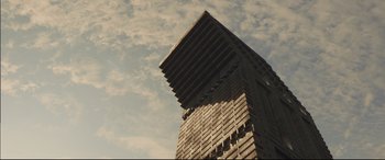 Movie still from “High-Rise” (2015), directed by Ben Wheatley – A tall building with a sky background in the background; Extreme Wide shot, Low angle