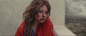 Movie still from “High-Rise” (2015), directed by Ben Wheatley – A young woman with a bruised face and a red blanket; Close Up shot, Over the shoulder angle