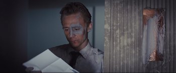 Movie still from “High-Rise” (2015), directed by Ben Wheatley – A person with a face paint on; Close Up shot, Low angle
