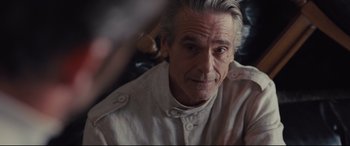 Movie still from “High-Rise” (2015), directed by Ben Wheatley – An older man is looking into the camera; Close Up shot, Over the shoulder angle