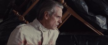Movie still from “High-Rise” (2015), directed by Ben Wheatley – An older man with grey hair looking to his left; Close Up shot, Low angle
