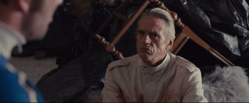 Movie still from “High-Rise” (2015), directed by Ben Wheatley – An older man with a knife in his mouth; Close Up shot, Low angle