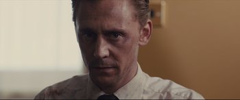 Movie still from “High-Rise” (2015), directed by Ben Wheatley – A person wearing a shirt and a tie; Close Up shot, Over the shoulder angle