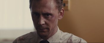 Movie still from “High-Rise” (2015), directed by Ben Wheatley – A person wearing a shirt and a tie; Close Up shot, Over the shoulder angle
