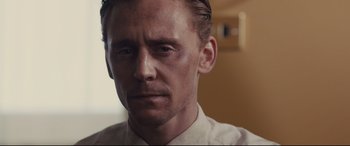 Movie still from “High-Rise” (2015), directed by Ben Wheatley – A person wearing a white shirt; Close Up shot, Over the shoulder angle
