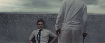 Movie still from “High-Rise” (2015), directed by Ben Wheatley – A man in a white shirt and tie sitting next to another man in a white shirt and tie; Medium shot, Low angle