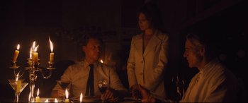 Movie still from “High-Rise” (2015), directed by Ben Wheatley – A man and a woman sitting at a dinner table; Medium shot, Over the shoulder angle