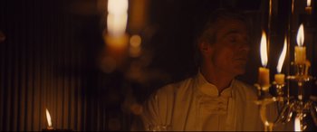 Movie still from “High-Rise” (2015), directed by Ben Wheatley – A man sitting in front of a lit candle; Close Up shot, Over the shoulder angle