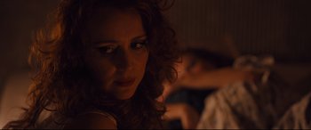 Movie still from “High-Rise” (2015), directed by Ben Wheatley – A person with curly red hair; Close Up shot, Over the shoulder angle