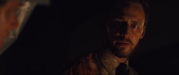 Movie still from “High-Rise” (2015), directed by Ben Wheatley – A person wearing a suit and tie; Close Up shot, Low angle