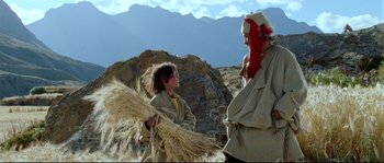 Movie still from “Himalaya” (1999), directed by Eric Valli – A man and a woman are standing in a field; Wide shot, Low angle
