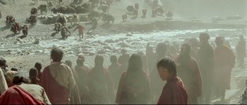 Movie still from “Himalaya” (1999), directed by Eric Valli – A group of people standing next to a herd of sheep; Extreme Wide shot, High angle